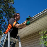 Worker repairing a gutter on a customers home.